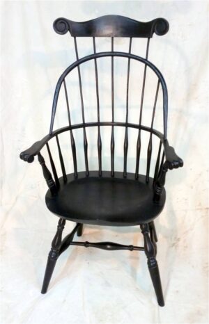 Sack back arm chair with comb and carved crest.
